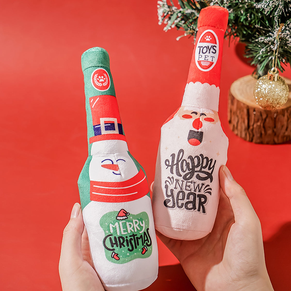 Hands holding the snowman and Santa Claus squeaky bottle toys