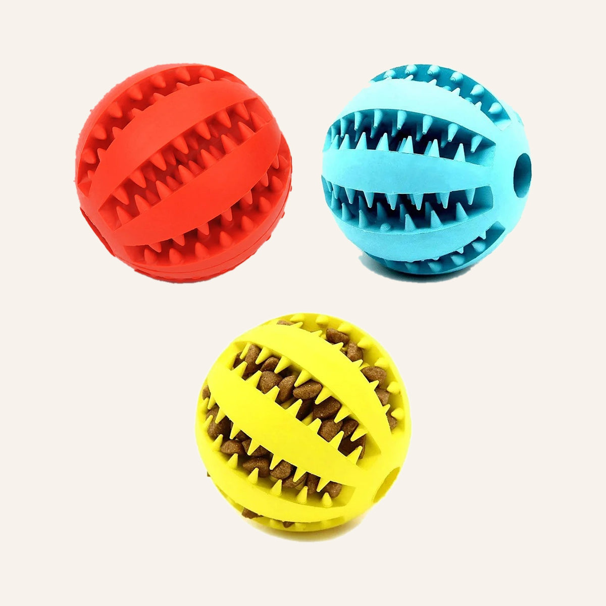 Red, teal and yellow rubber treat balls with toothy ridges, the yellow one filled with kibble