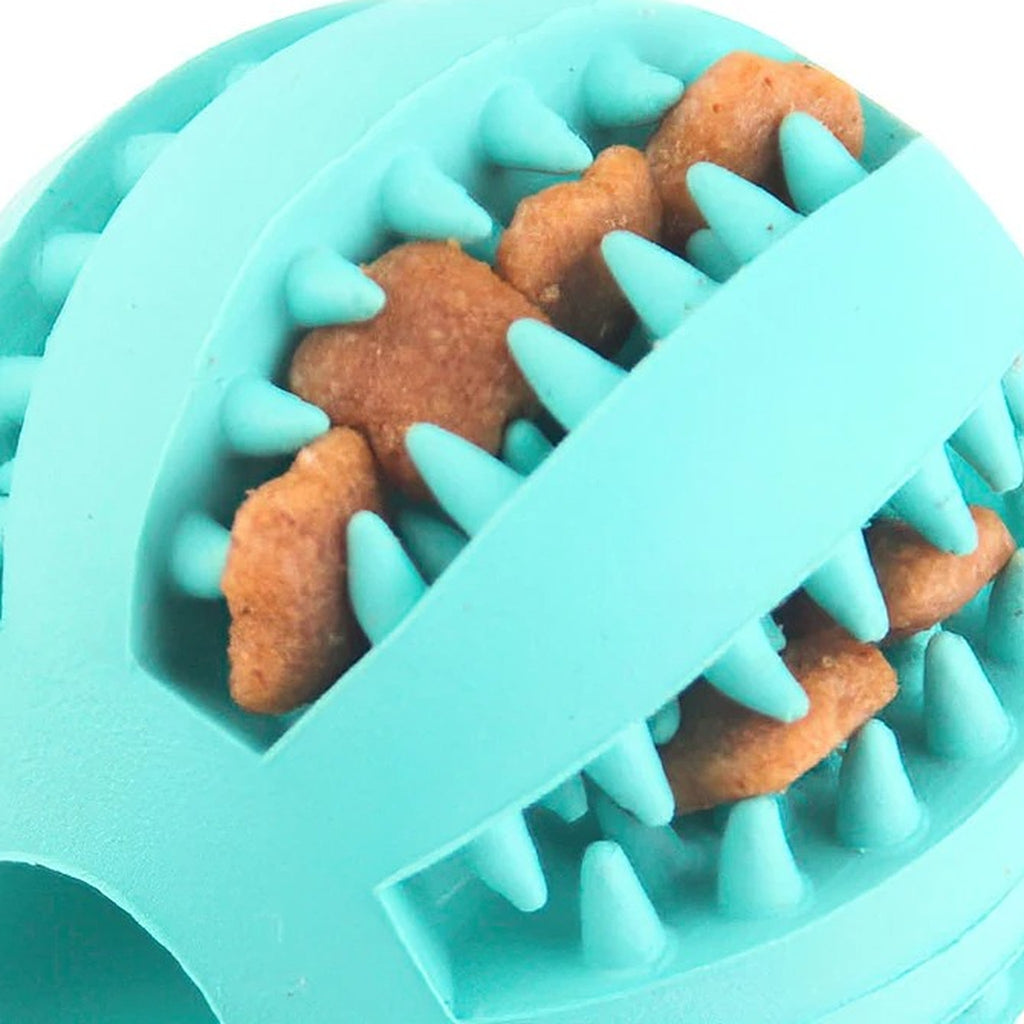 Close-up of kibble wedged between the rubber teeth of a teal treat ball