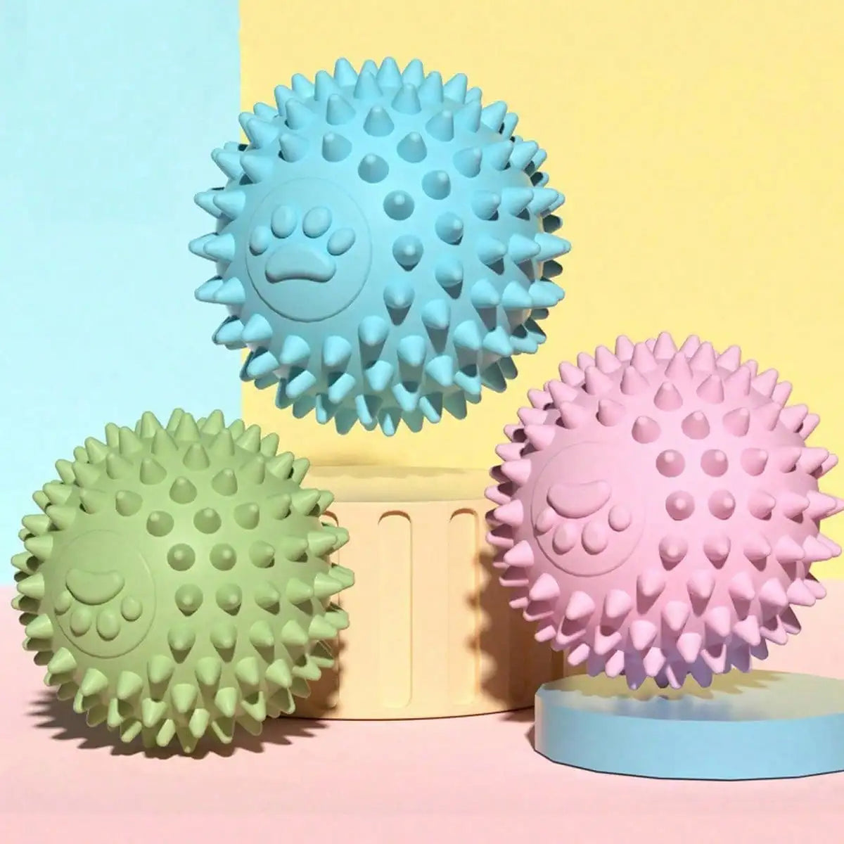Blue, green and pink spiky rubber balls on pastel stands